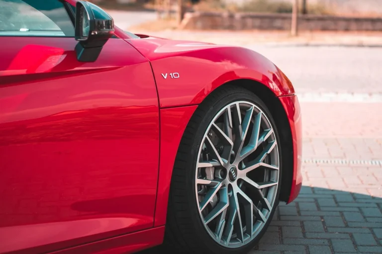 A host checks a sedan and paperwork in a driveway while evaluating Turo Go eligibility.