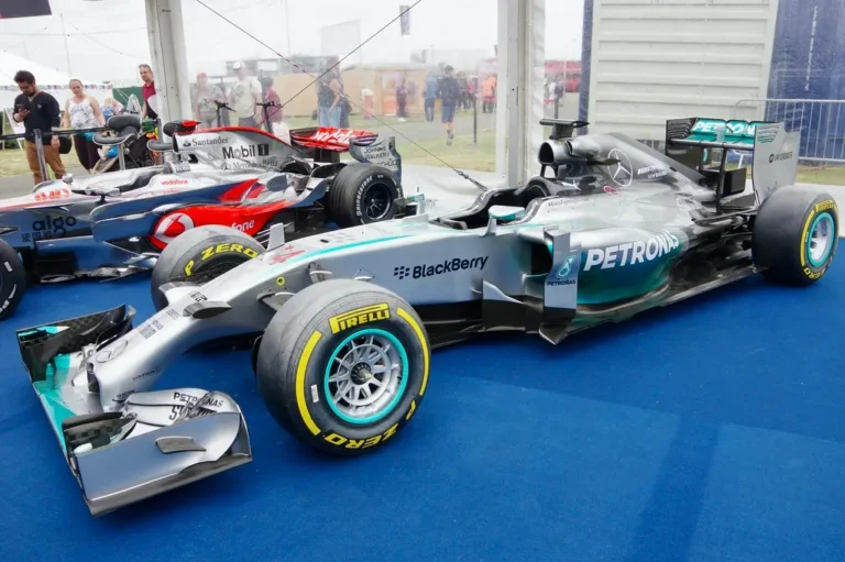 Red Bull Formula 1 race car in a pit lane with mechanics and garage lights in the background