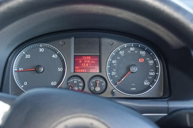BMW mechanic inspecting an engine bay with a scan tool and warning light visible
