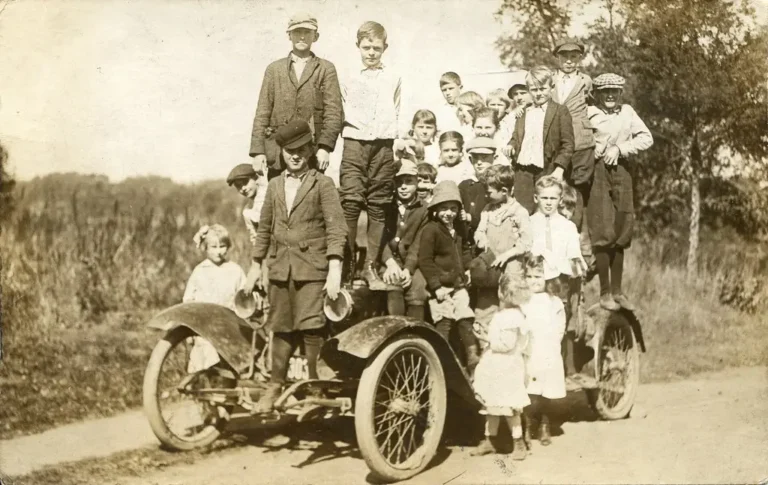 Karl Benz's early Motorwagen displayed beside a historian in natural light