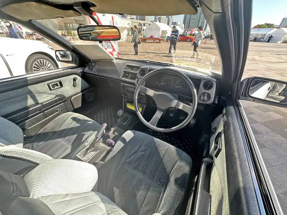 Technician connecting a sensor module inside a vehicle dashboard test setup