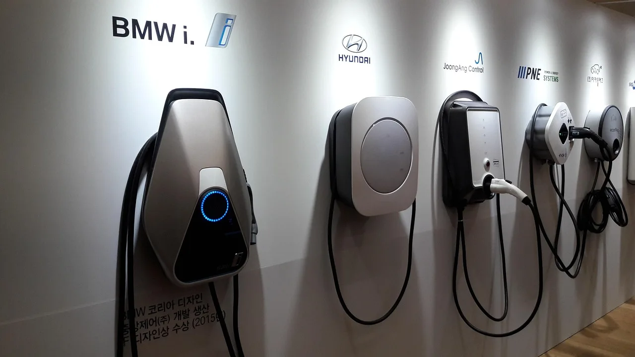 Driver checking a car charger beside an electric car at a public charging station