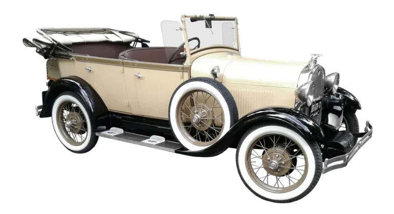 Classic coupe with polished wire wheels parked in natural light, showing period-correct stance and tire fitment.